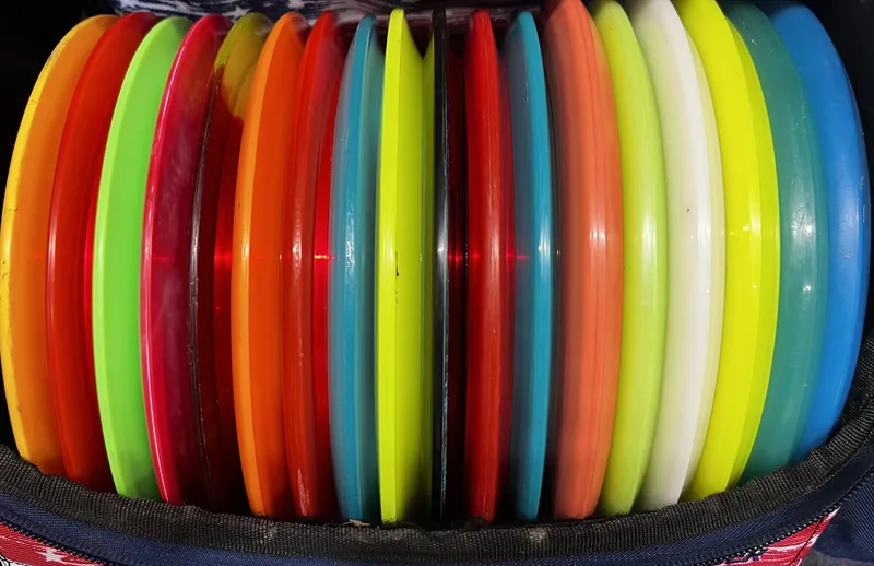 Close-up of a disc golf bag packed with colourful disc rims