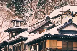 Snow on the wooden inns of an onsen town