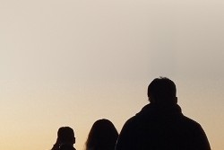 People walking toward a sunset